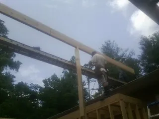 Carpenter setting a ridge beam over a new addition frame — Ice Dam Removal by Roofing Brothers in Prosper