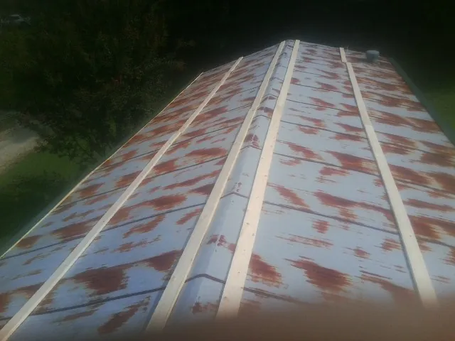 Rusted metal roof panels with new wood purlins before replacement — Storm Damage Roof Repair in Prosper by Roofing Brothers