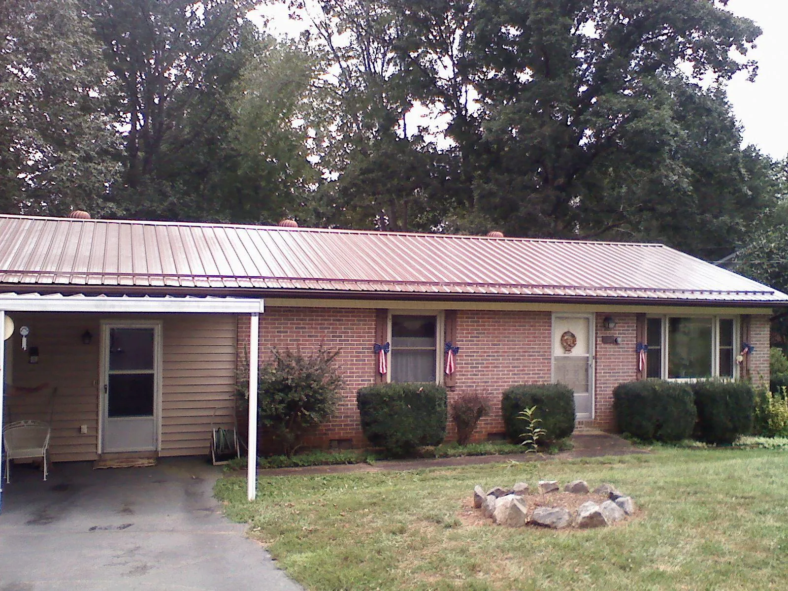 Bronze metal roof and carport on a brick ranch home — Roof Repair work by our crew in Prosper